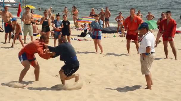 Pendant le combat, l'athlète sur la plage de sable entre dans vos yeux — Video