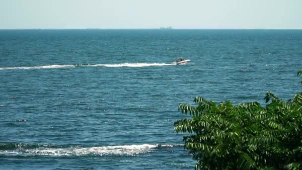 Bateau à moteur flottant dans la mer. Vue depuis le rivage — Video