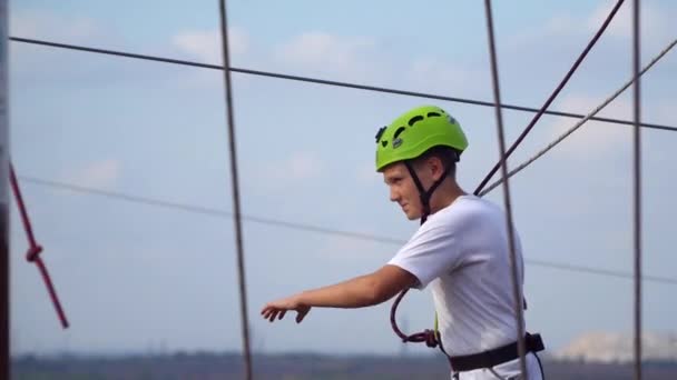 Tinédzser megy a lengő gerendák Rope park — Stock videók