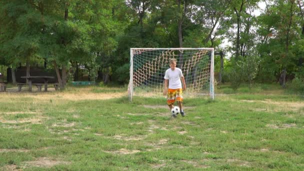 Adolescente praticando com uma bola de futebol — Vídeo de Stock