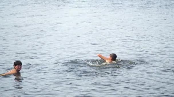 Teenager next to the mother swims in the lake — Stock Video