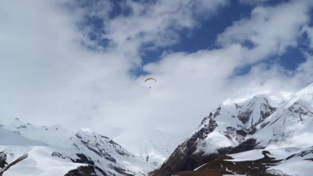 Paralotniarz Lata Wśród Ośnieżonych Gór Nagranie Zrobione Przez Drona Kaukaz — Wideo stockowe