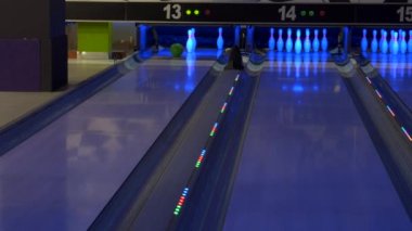 Bowling maçı. Bir bowling topu yolda ilerliyor ve lobutları deviriyor..