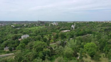 Şehir bahçesinin kuş bakışı görüntüsü. Ağaçların arasında bir cami görebilirsin.