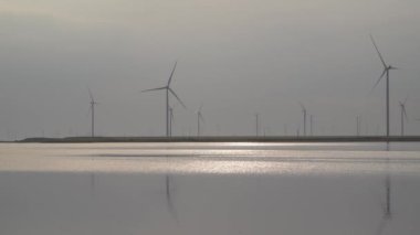 Akşamları rüzgar türbinleri gölde.
