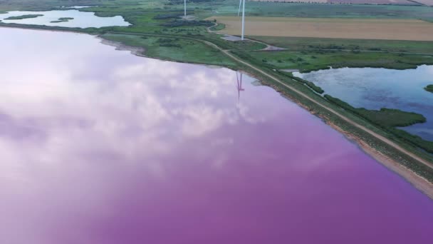 Lotu Ptaka Widać Różowe Jezioro Chmury Turbiny Wiatrowe Odbijają Się — Wideo stockowe