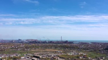 Çelik fabrikasının panoramik görüntüsü. Bitki şehirde yer almaktadır, bitkinin arkasında deniz vardır. Hava görünümü