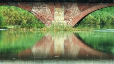 Köprü taşıyan tuğla yapılmış nehre yansıtılır