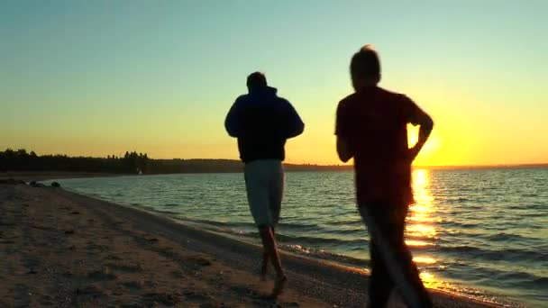 Dos tipos corriendo por la playa — Vídeos de Stock