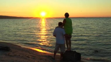 Erkek ve kadın gün doğumunu izlemek plajı ile