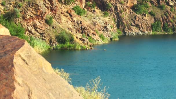 Gente en la orilla de un lago de montaña — Vídeo de stock