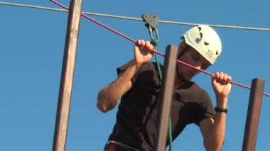 Adam yol ip üzerinde bir engel üstesinden gelir.