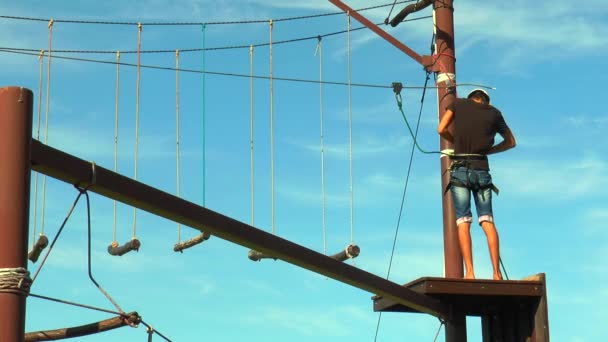 Człowiek rozwiązuje liny bezpieczeństwa Park linowy — Wideo stockowe