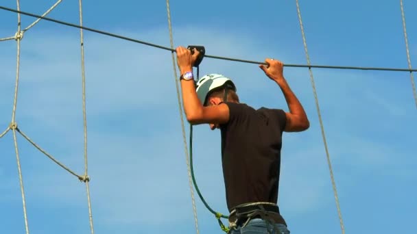 Hombre sosteniendo la cuerda y va por el camino de la cuerda — Vídeos de Stock