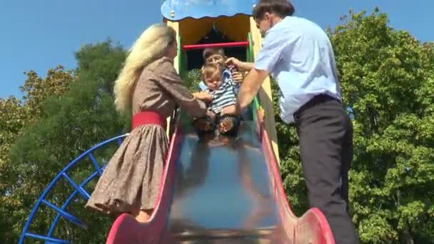 Orangtua dengan anak-anak naik slide balita — Stok Video