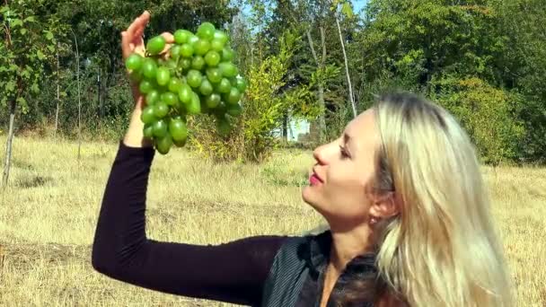 A menina está segurando um monte de uvas — Vídeo de Stock