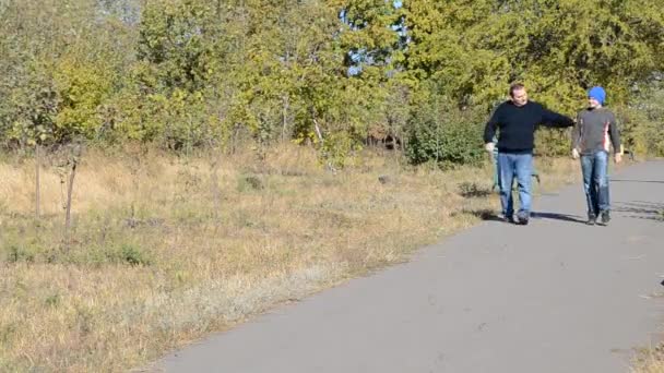 Padre e figlio sono nel vicolo nel parco autunnale — Video Stock