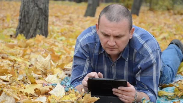 Чоловік на землі з планшетом — стокове відео