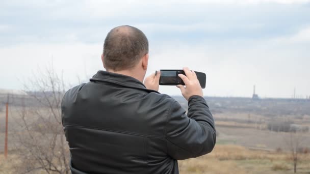 Um homem tira fotos com seu telefone — Vídeo de Stock