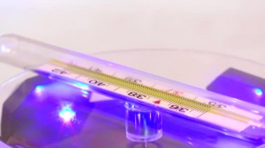 Mavi aydınlatmalı masada döndürülmüş termometre