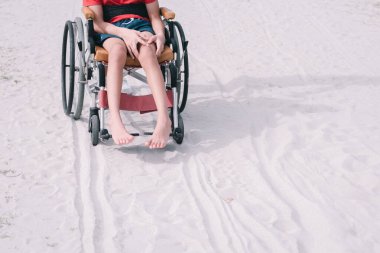 Asian special child on wheelchair is smiling, playing, doing activity on  sea beach with father,Lifestyle of disability child, Life in the education age, Happy disabled kid in travel holidays concept.