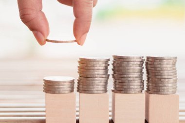 Metin veya kelime, Eğitim, İş, Tasarruf veya bankacılık konsepti, Seçici odaklanma için tasarım veya sanat çalışmaları için doğa arka planına sahip para yığınları ve dört tahta blok üzerindeki ahşap blok.