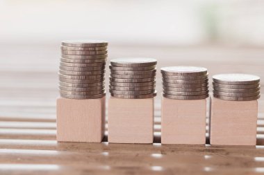 Metin veya kelime, Eğitim, İş, Tasarruf veya bankacılık konsepti, Seçici odaklanma için tasarım veya sanat çalışmaları için doğa arka planına sahip para yığınları ve dört tahta blok üzerindeki ahşap blok.