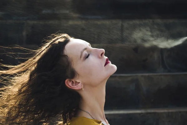 Genç kadın yüz termal su ile yenileniyor. Zevk, cilt bakım kavramı.