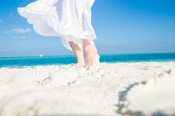 Beyaz etek ve ayak tropik sahilde kum taşıma — Stok fotoğraf