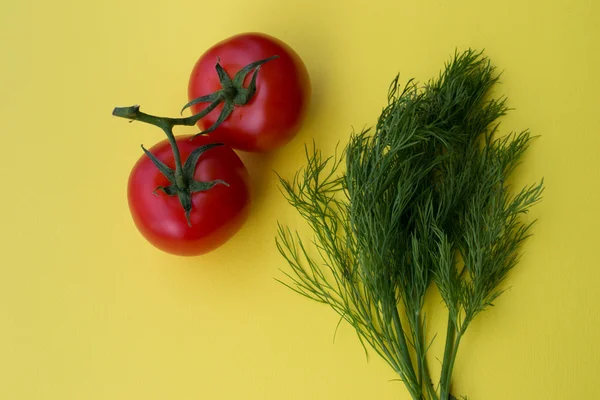 Dill and two tomatoes on yellow background — Stock Photo, Image