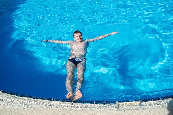 Adam yalan yüzme havuzunda su yüzeyi — Stok fotoğraf