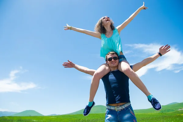 Happy couple with open arms, girl sitting on shoulders man — Stock Photo, Image