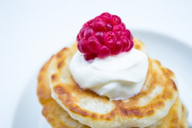 Stack of pancakes on plate  raspberries and sour cream, close-up