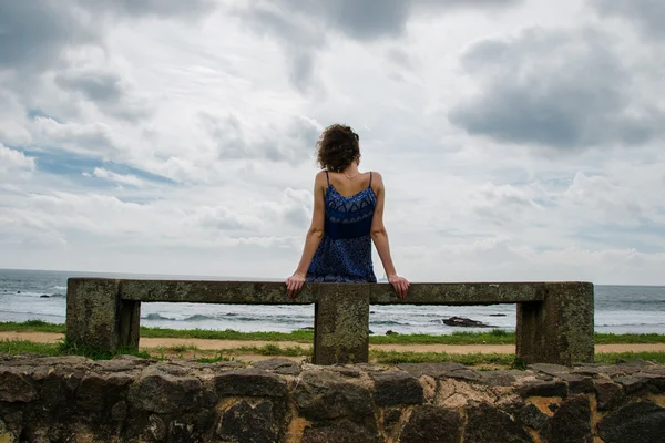 Woman sitting on bench near sea, horizontal — Stock Photo, Image