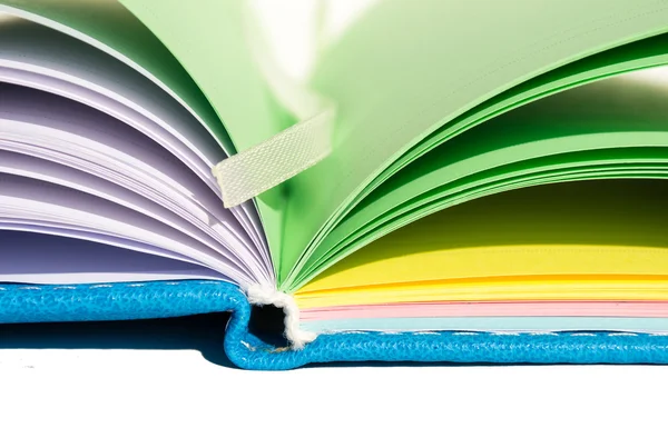 Open varicolored notebook on surface, horizontal — Stock Photo, Image