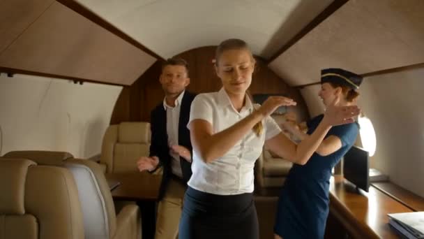 Предприниматели и стюардесса танцуют внутри самолета первого класса — стоковое видео