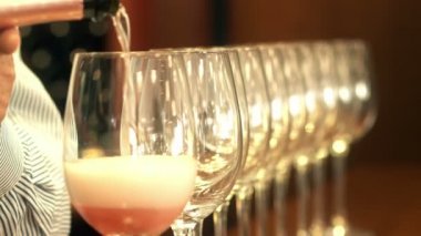 Sommelier el yağan gül şarap bir satıra kristal bardak
