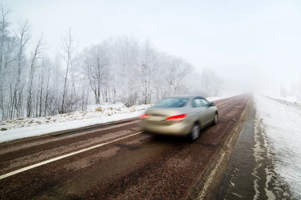 Voiture à grande vitesse capturée avec un mouvement flou sur des conditions hivernales — Photo