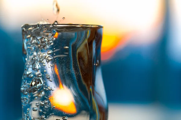 Misted Glass med koldt alkohol drikke eller vand og pulserende solnedgang - Stock-foto