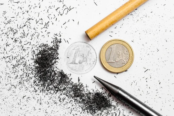 Два карандаша и одна монета евро — стоковое фото