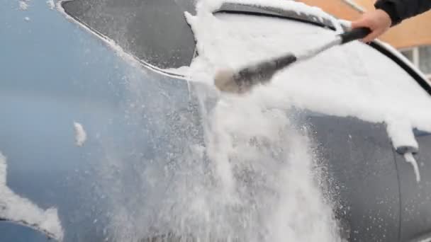 El hombre limpia el coche de la presa de nieve — Vídeo de stock