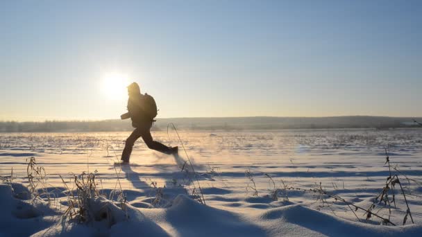 El hombre corre sobre la nieve y deja huellas — Vídeo de stock