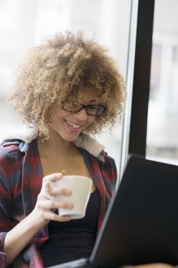 Bir dizüstü bilgisayarda çalışırken tutan kız