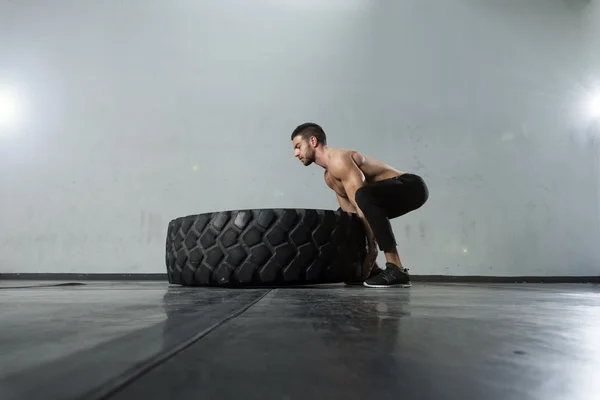 健美运动员在健身房翻转轮胎 — 图库照片