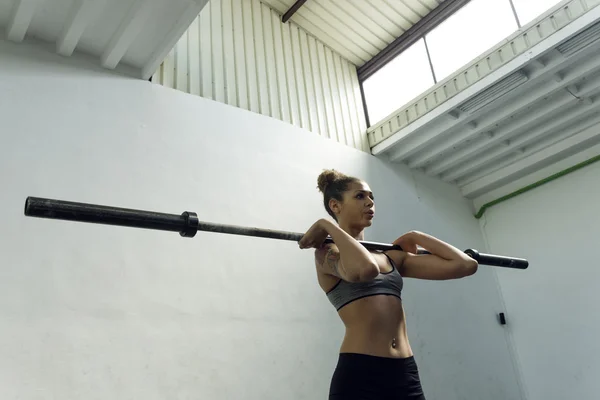 Niña levanta la barra del peso en el gimnasio — Foto de Stock