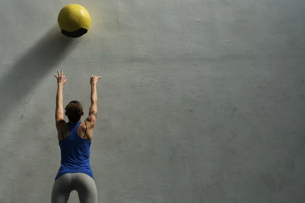 Mujer haciendo ejercicio de pelota de pared Imagen De Stock