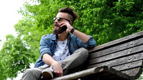 Homme à la mode assis sur le banc dans le parc — Video