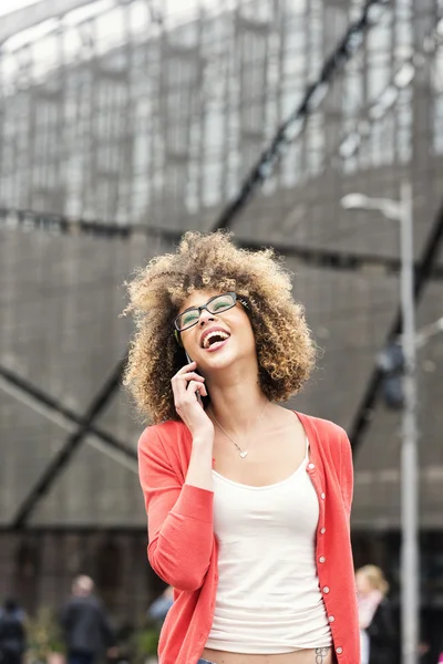 Young mixed race woman talking on the phone at the street — Stock Photo, Image