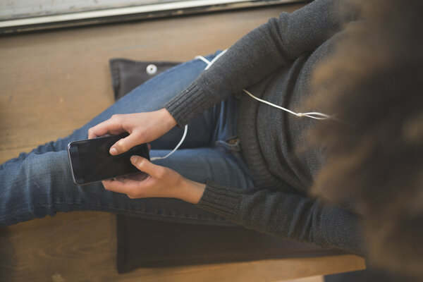 Красивая девушка пьет кофе и работает на ноутбуке в кафе
