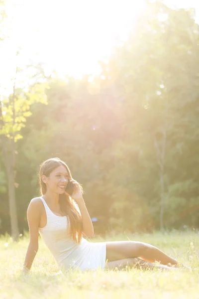 Giovane ragazza che parla al telefono nel parco — Foto Stock